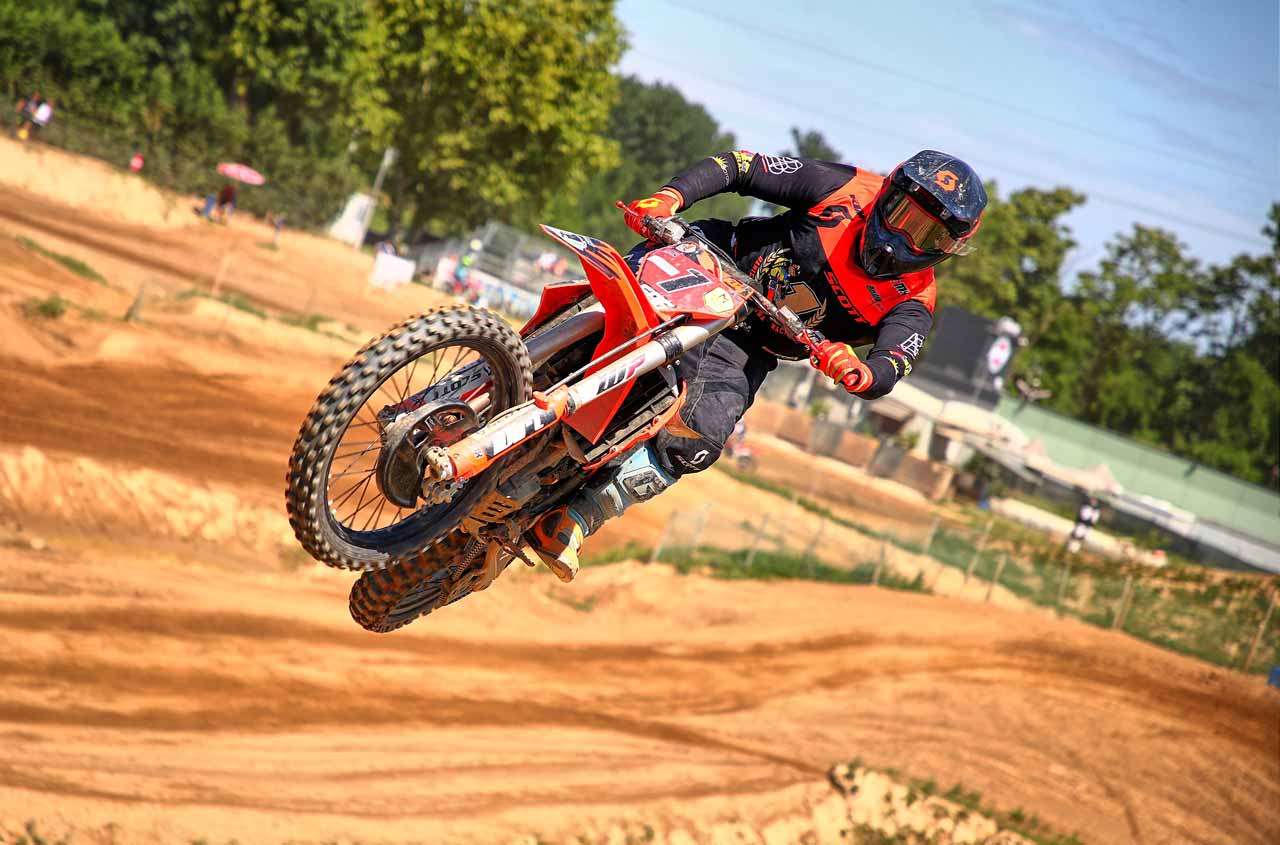 Pilota di motocross in salto sulla pista